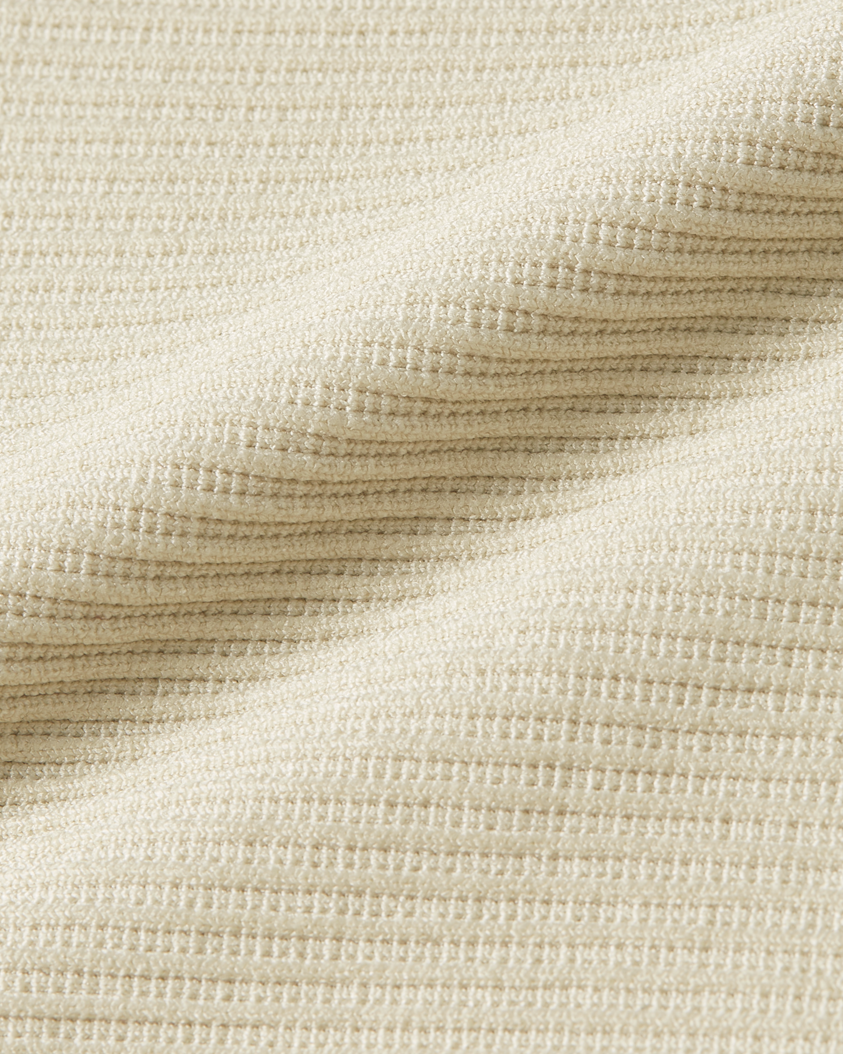 Fabric detail of beige ribbed bodysuit focusing on a refined texture with gentle elasticity and a soft touch finish