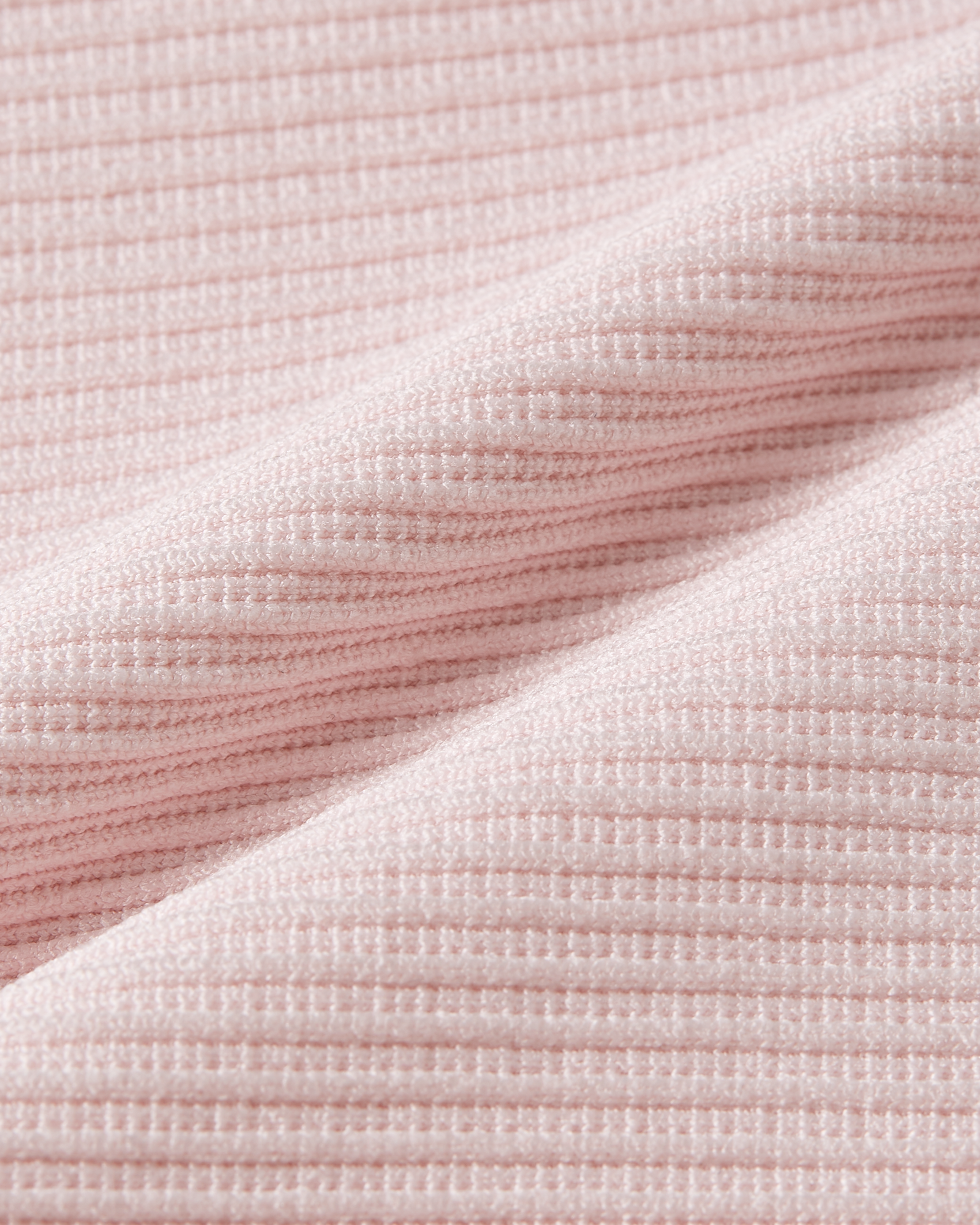 Fabric detail of pink ribbed bodysuit focusing on a refined texture with natural elasticity and a soft touch finish