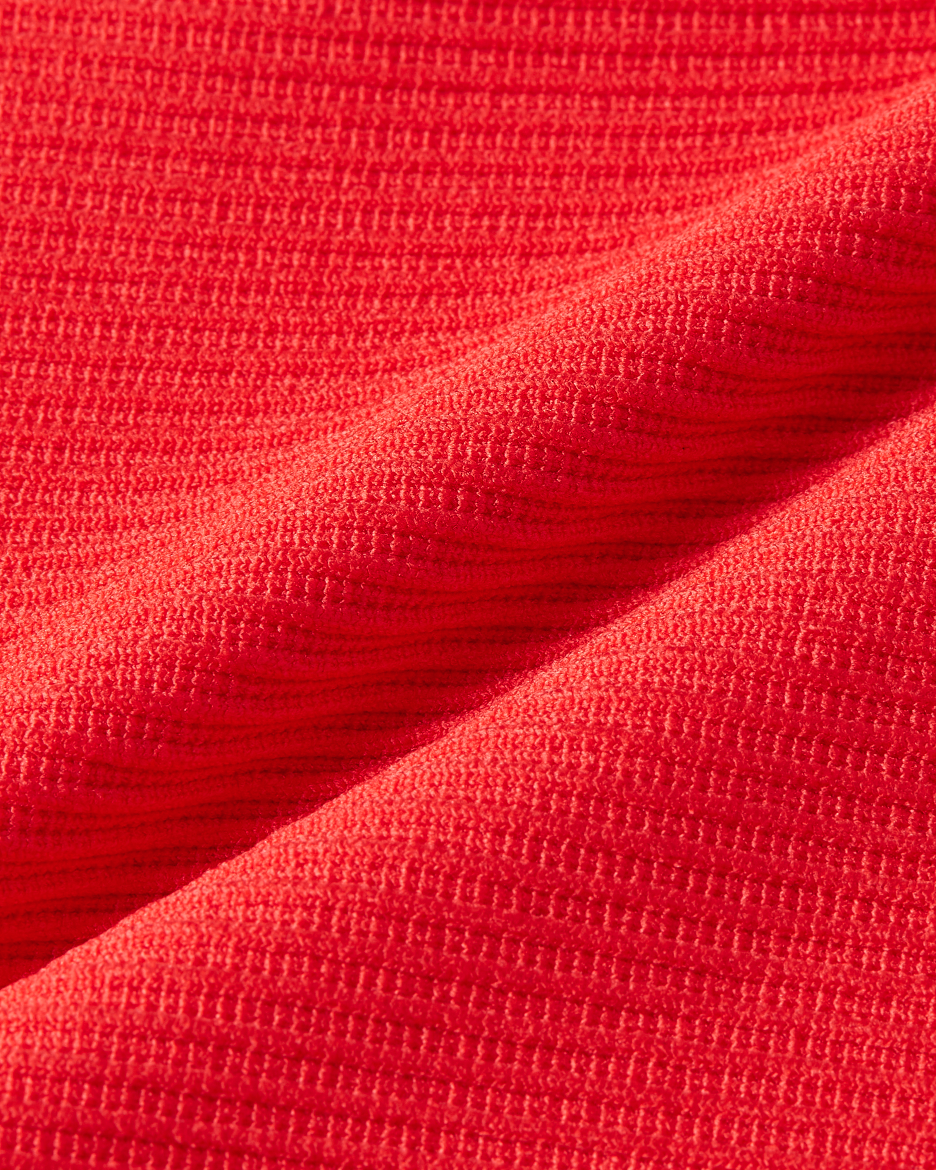 Detailed view of red ribwear fabric with a rich and even structure designed to follow the body comfortably product image