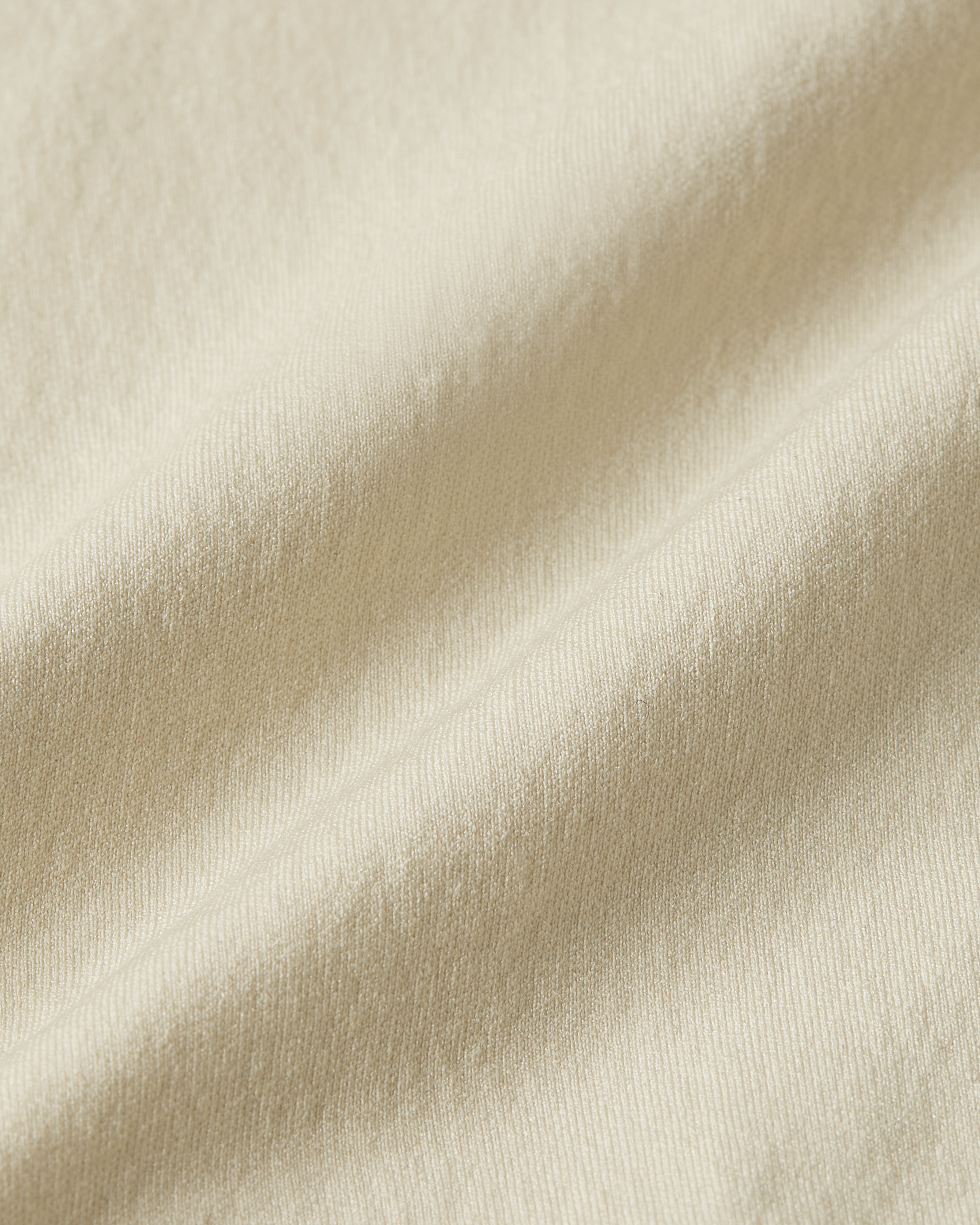 Close up detail of beige shapewear bodysuit showing supportive stretch fabric with a soft structure and natural flexibility
