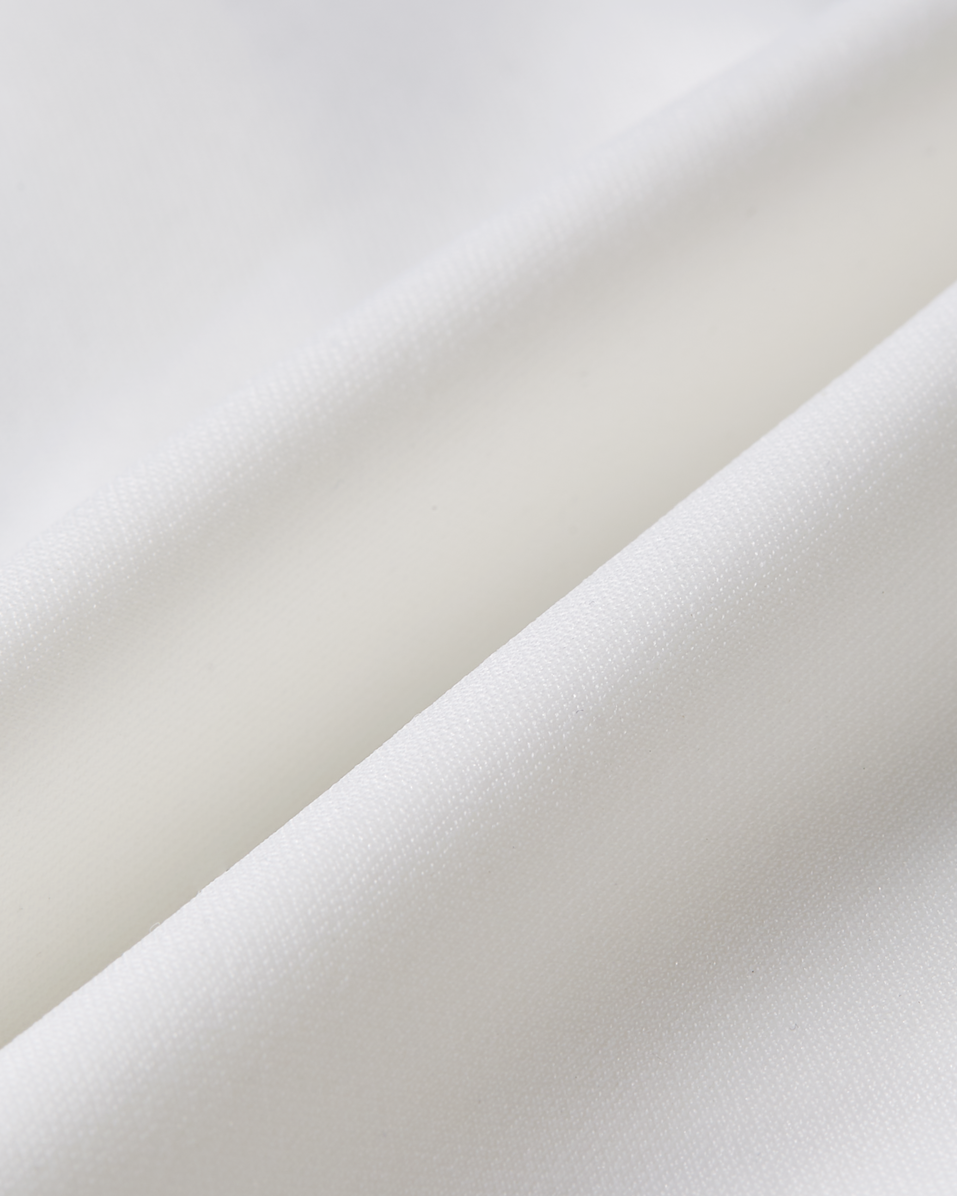 Fabric detail of white laser cut bralette focusing on a refined texture with a soft touch and smooth construction