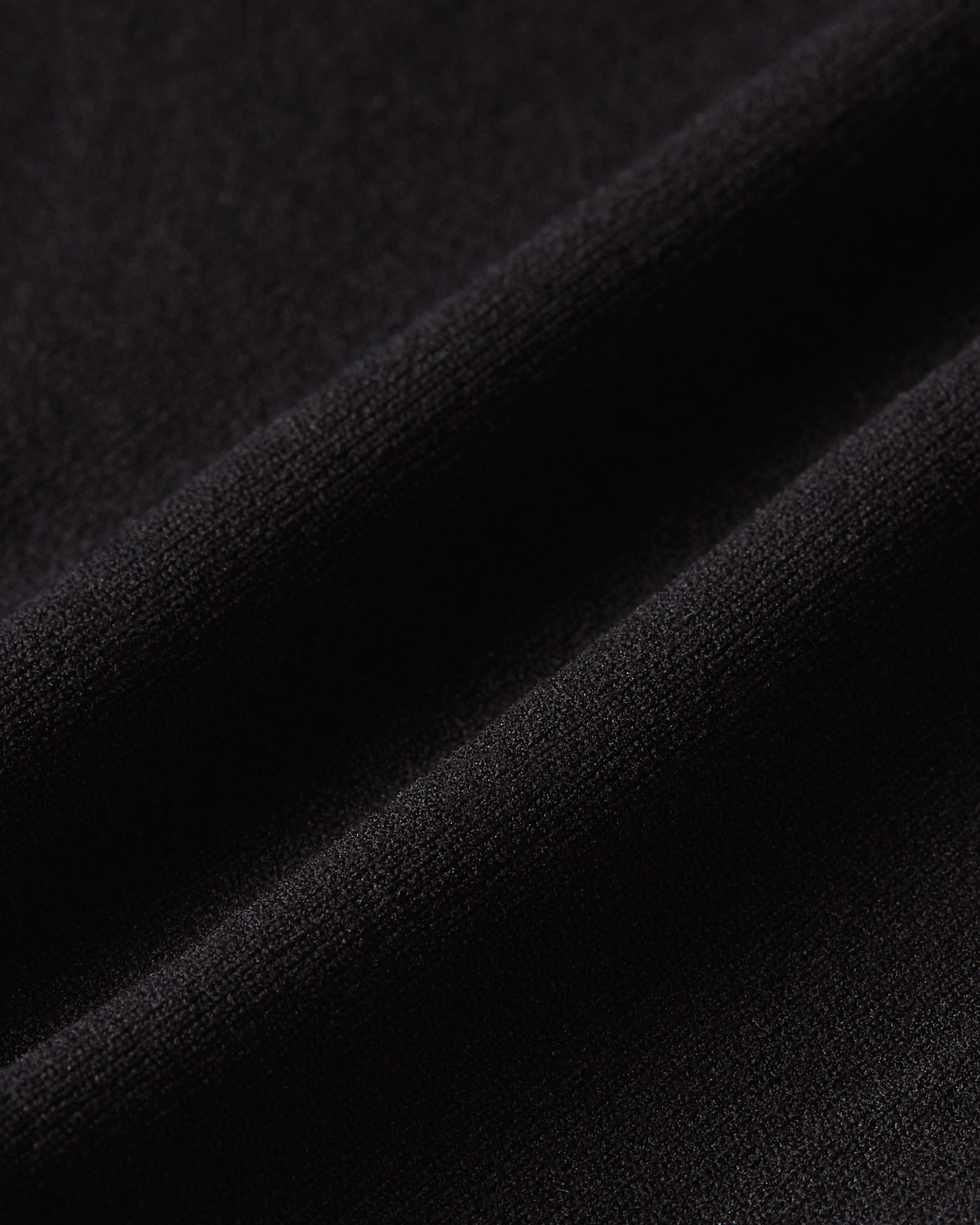 Detailed view of black brazilian fabric with a smooth structure designed to sit comfortably and remain invisible under clothing