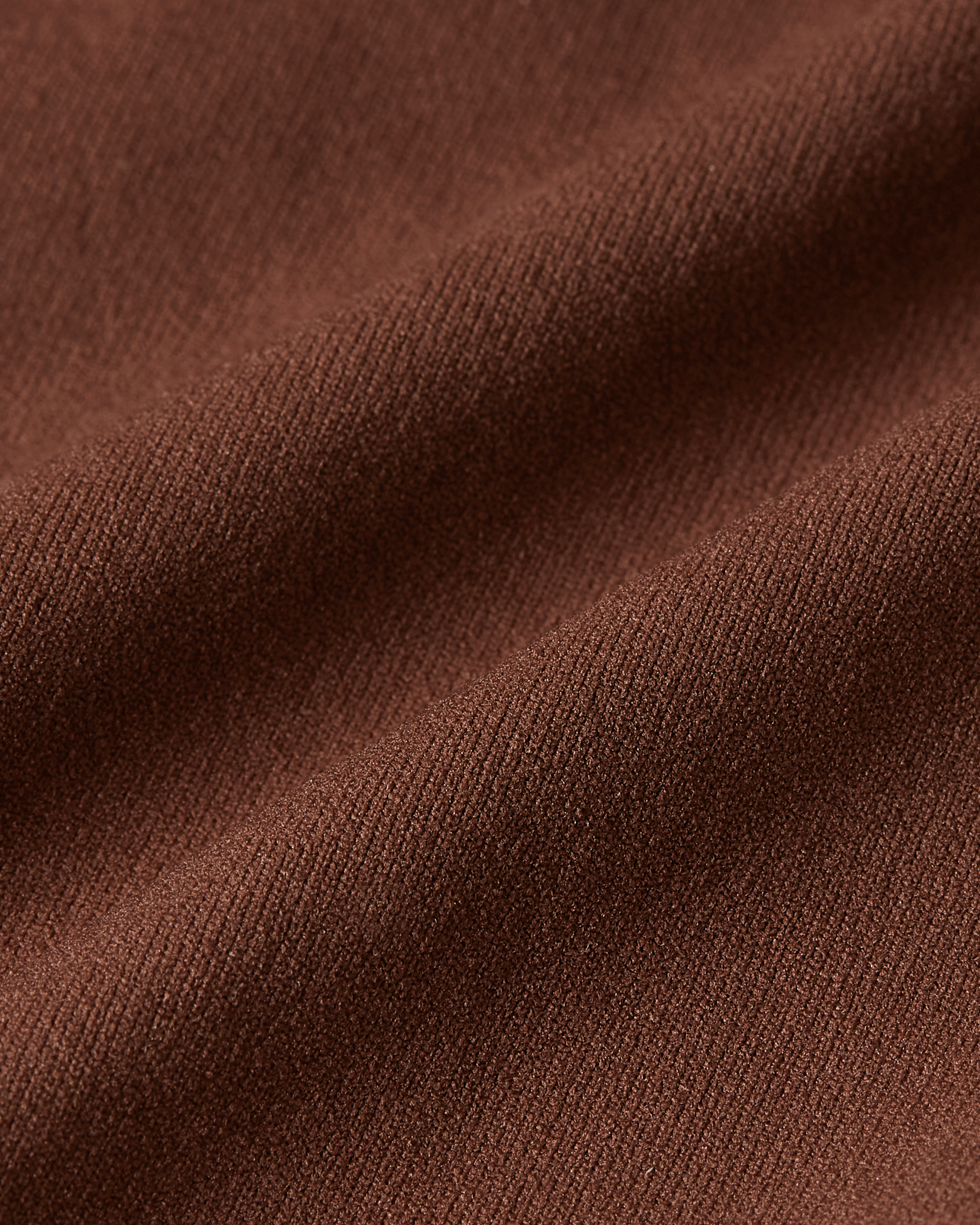 Close-up detail of brown Essentials brief fabric, highlighting the warm earthy tone, soft-touch texture, and flexible, body-hugging stretch