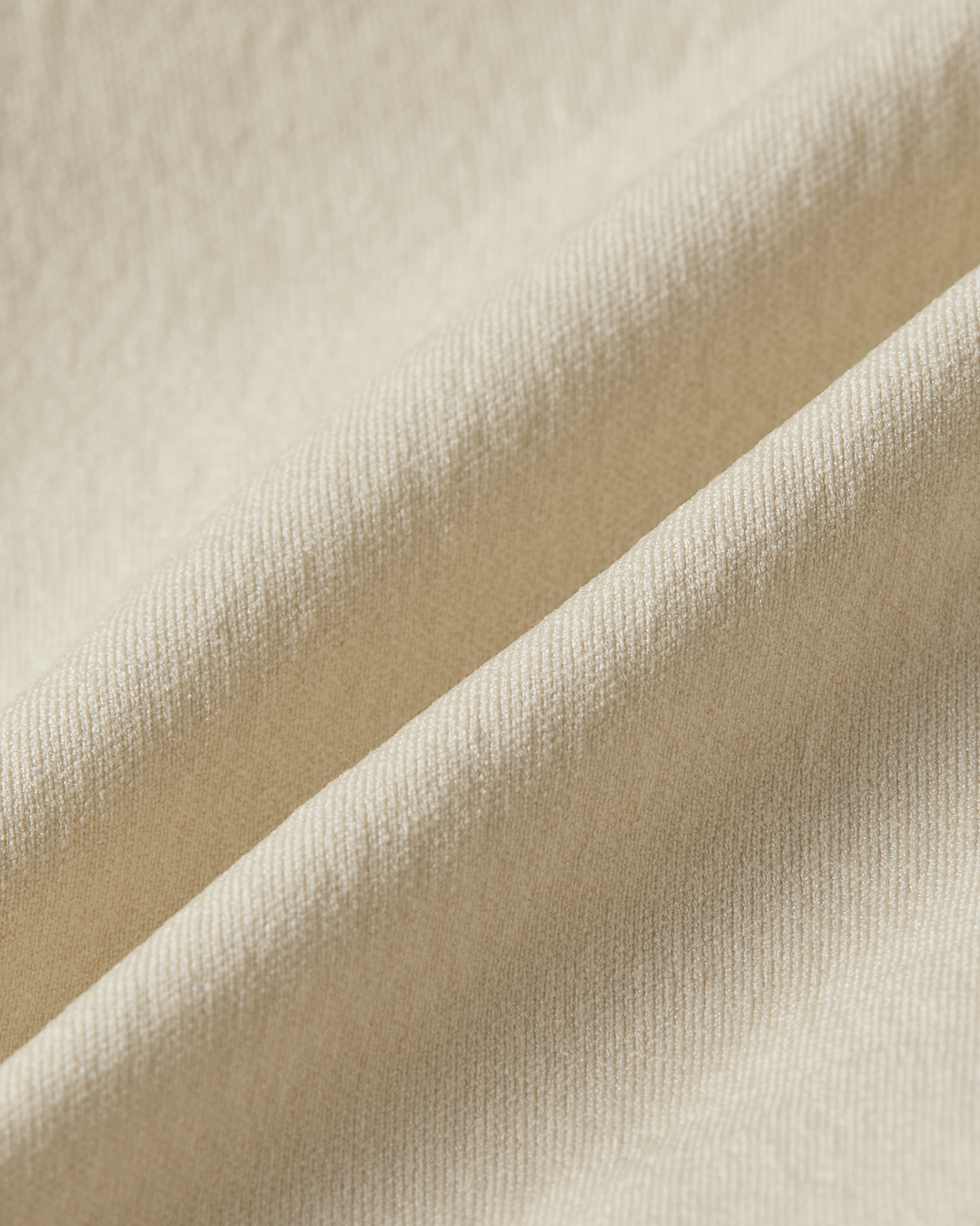 Detail product image of beige shapewear shorts fabric showing a smooth and supportive texture with a soft and refined feel