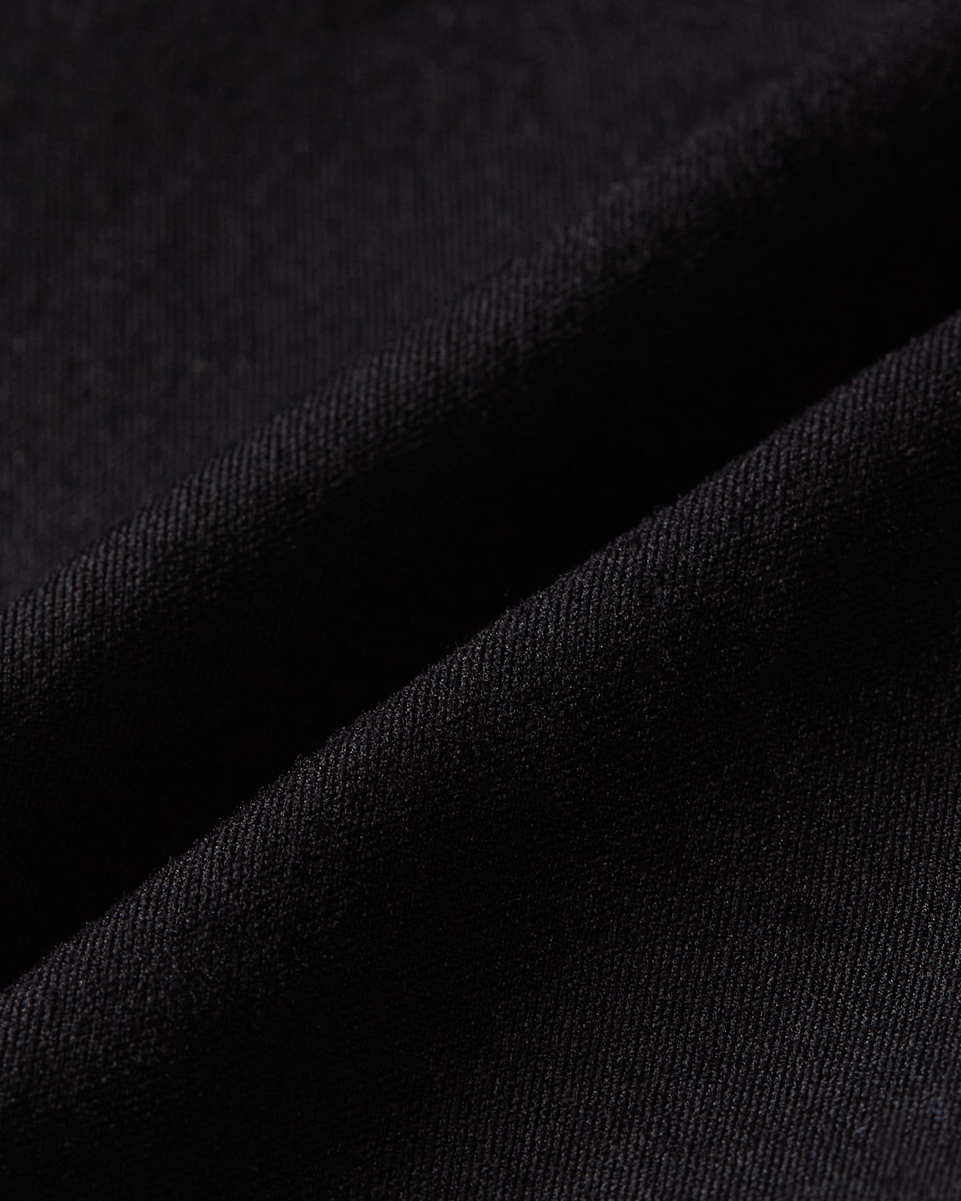 Detail product image of black shapewear shorts fabric showing a smooth and dense texture with firm and supportive stretch