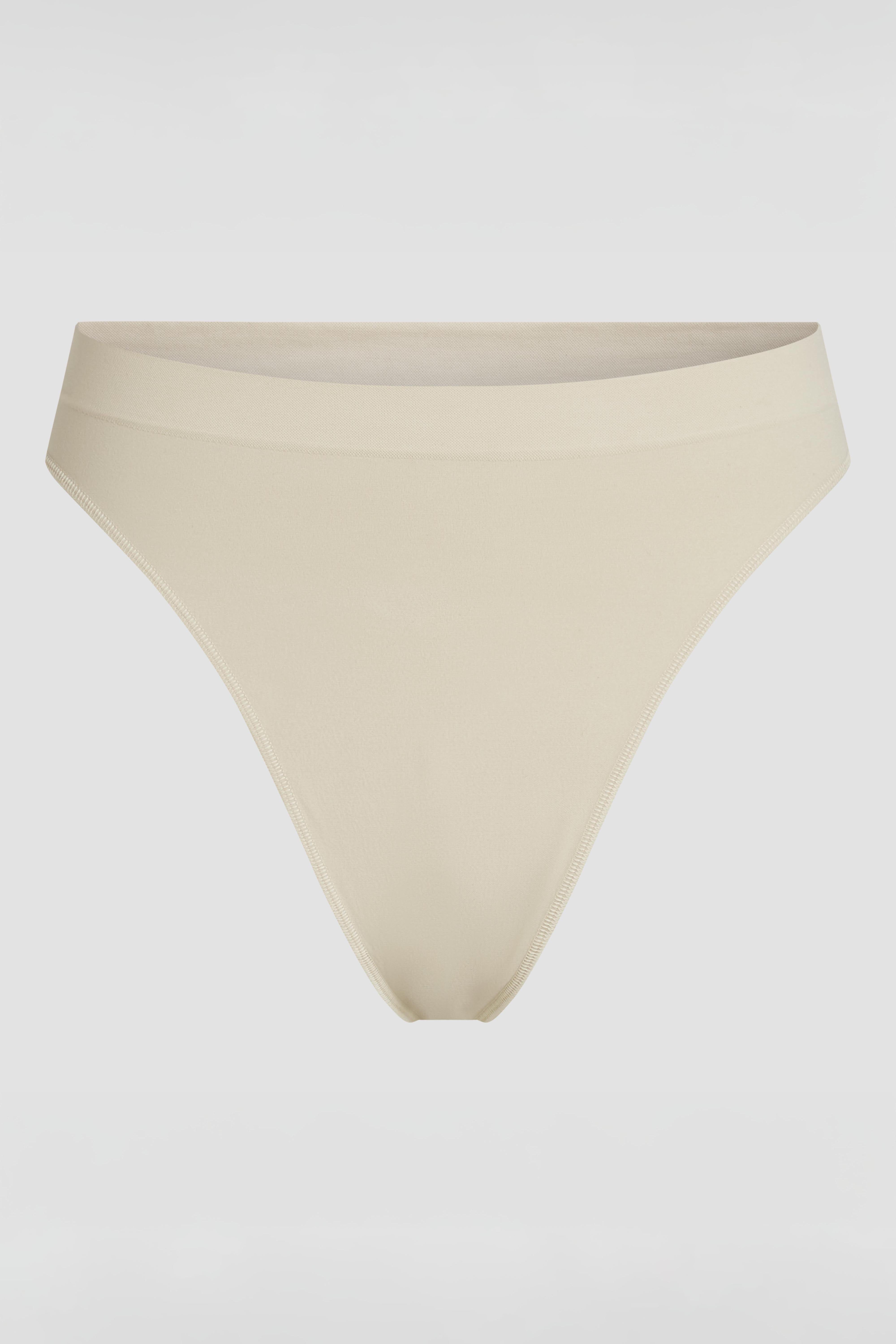Beige shapewear thong product photo with subtle tummy shaping and invisible seamless fit