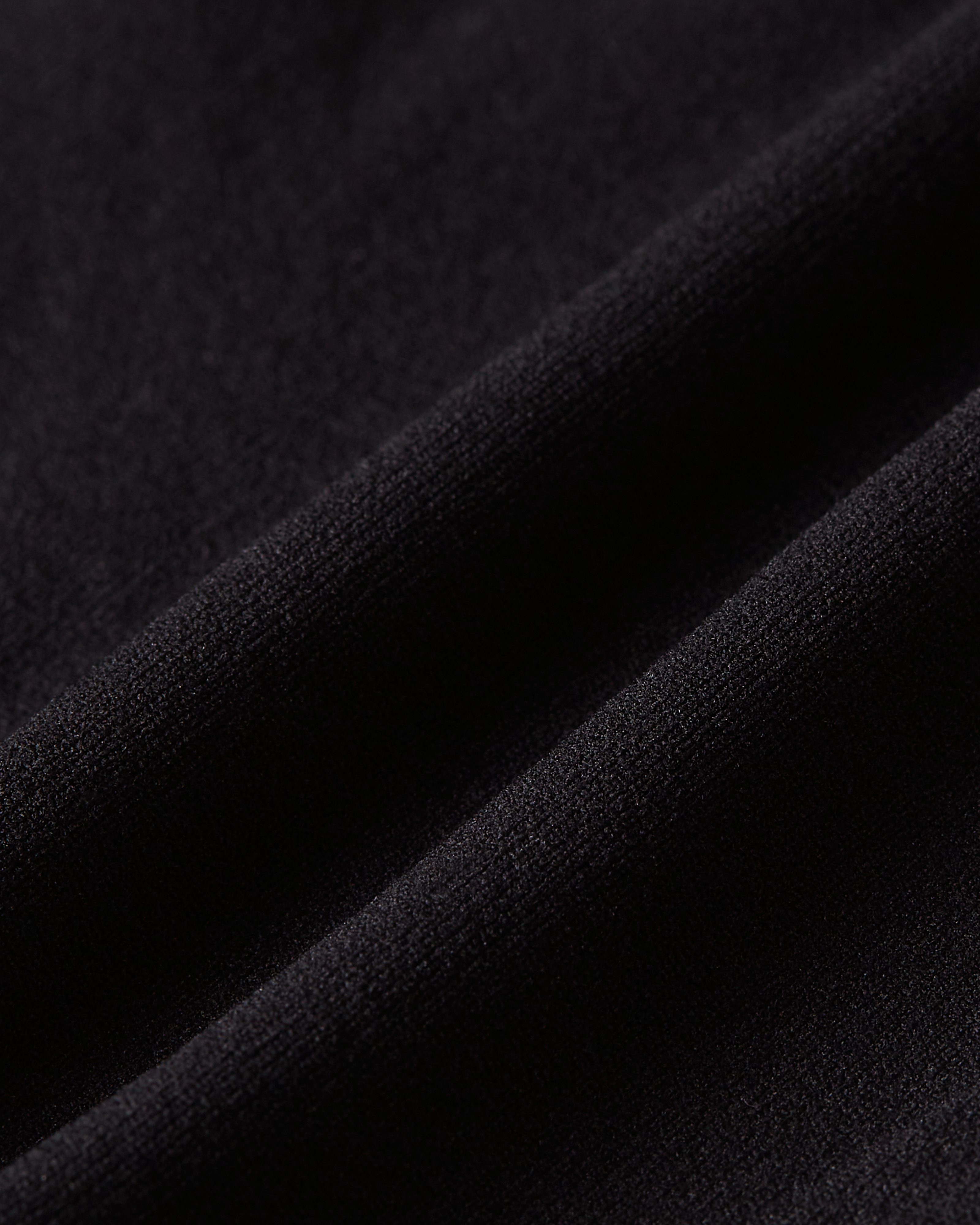 Close up of black thong shapewear showing flexible stretch material that moves naturally with the body