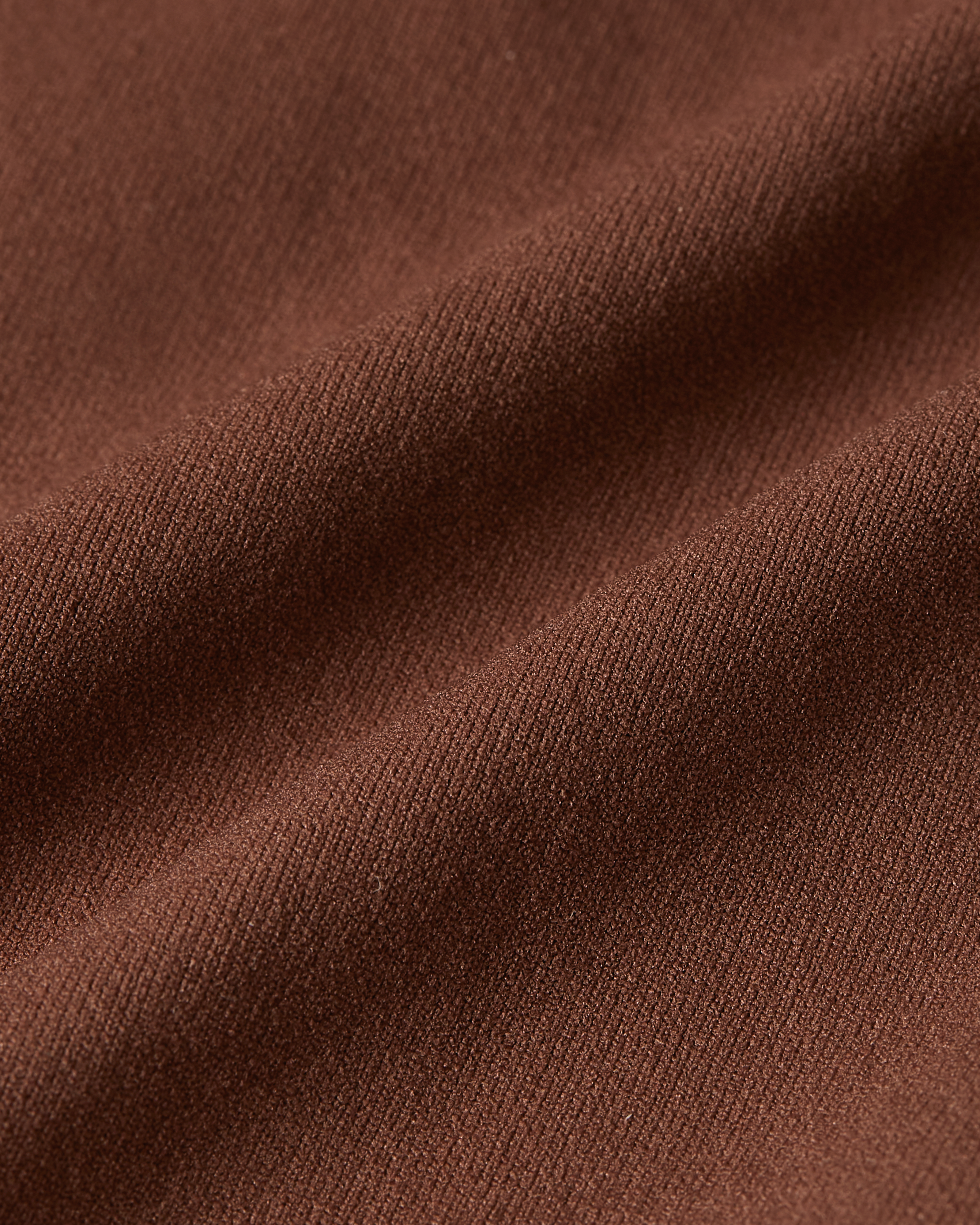 Detail shot of brown Essentials thong fabric, showcasing the rich tone, fine weave, and flexible, second-skin feel of the material