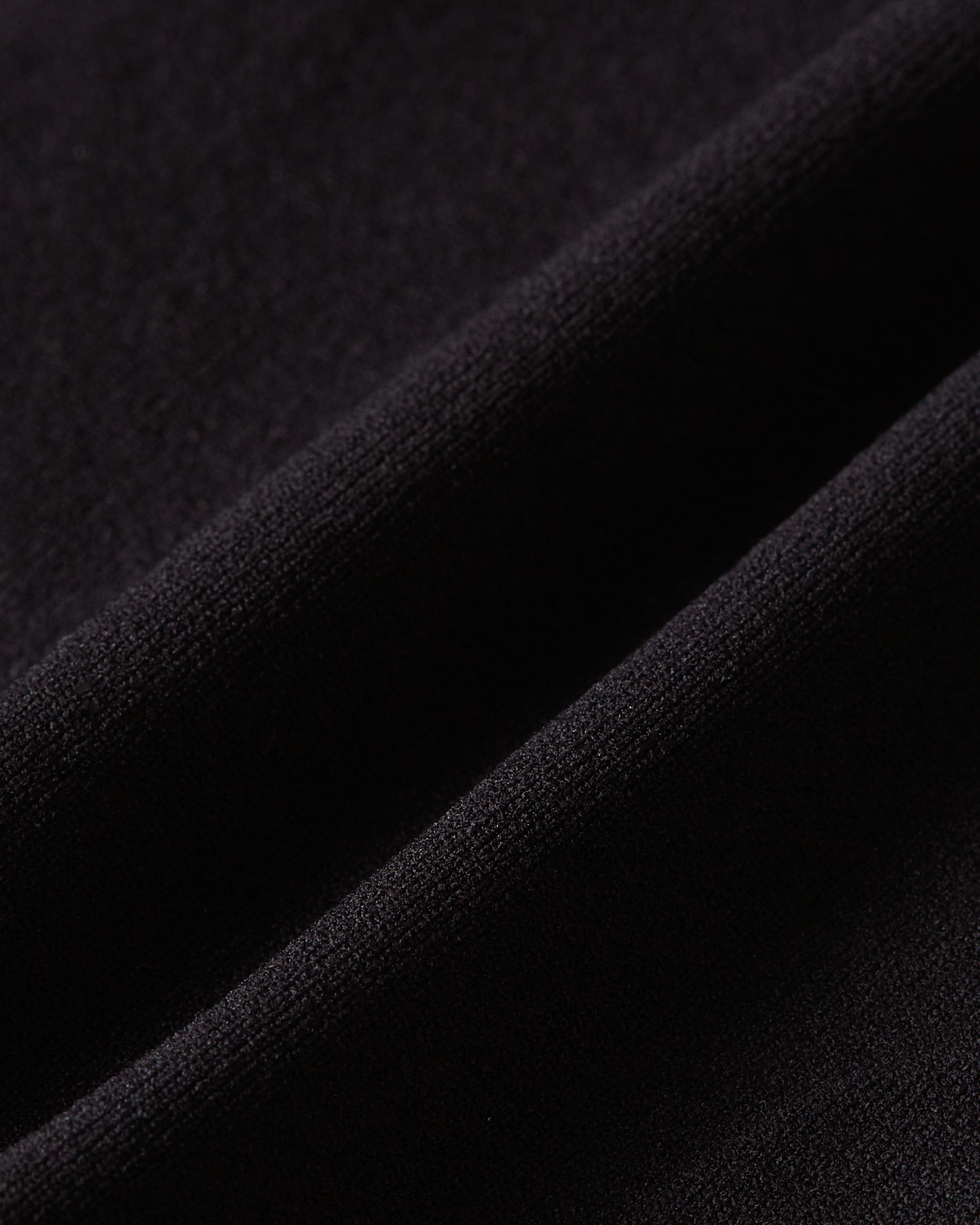 Macro detail of black Essentials brief fabric, showcasing the rich tone, ultra-smooth surface and comfortable stretch for a second-skin feel