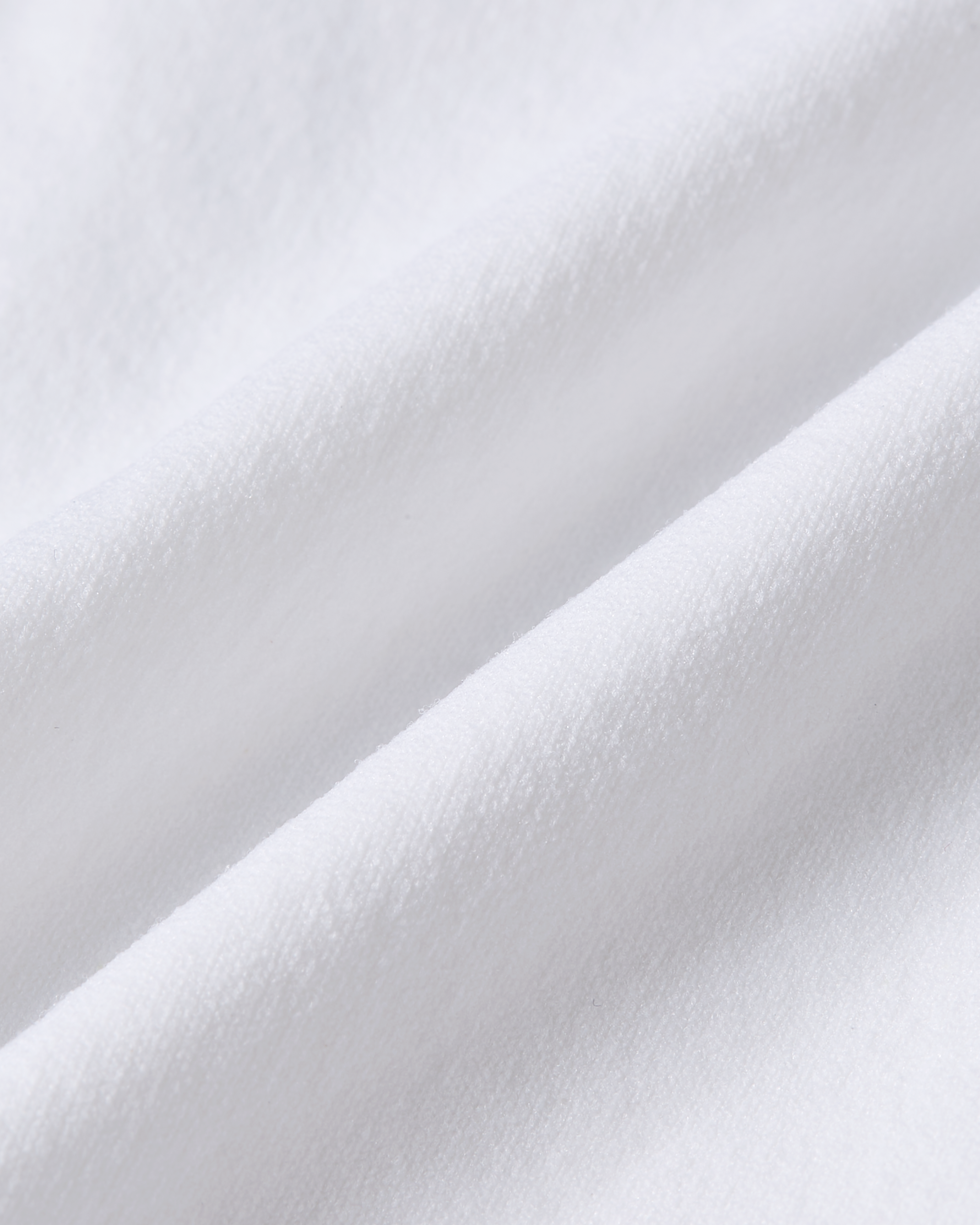Detail image of white Essentials brief fabric, emphasizing the clean bright tone, smooth surface and breathable, softly structured feel